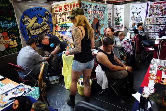 Body art enthusiasts receive tattoos. (Photo by Oli Scarff/Getty Images)
