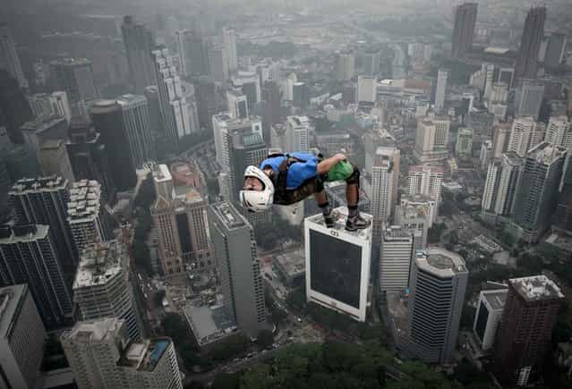 Base jumper Denis Odintsov from Russian leaps from the 300-meters Open Deck of the Malaysia's landmark Kuala Lumpur Tower during the International Tower Jump in Kuala Lumpur on September 27, 2013. Some 103 professional base jumpers from 20 countries are taking part in the annual event. (Photo by Mohd Rasfan/AFP Photo)