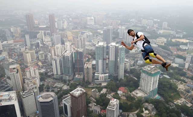 Base jumper Kristian Moxnes of Norway leaps from the 300-meter Open Deck of the Malaysia's landmark Kuala Lumpur Tower during the International Tower Jump in Kuala Lumpur, Friday, September 27, 2013. (Photo by Vincent Thian/AP Photo)