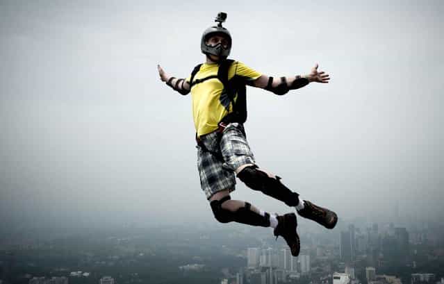 Base jumper Sergey Yunishev of Russia leaps from the 300-metres Open Deck of Malaysia's landmark Kuala Lumpur Tower during the International Tower Jump in Kuala Lumpur on September 27, 2013. (Photo by Mohd Rasfan/AFP Photo)