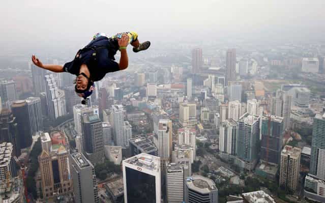 Base jumper Vincent Philippe Benjamin Reffet from France leaps from the 300-metres Open Deck of the Malaysia's landmark Kuala Lumpur Tower during the International Tower Jump in Kuala Lumpur on September 27, 2013. (Photo by Mohd Rasfan/AFP Photo)