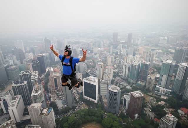 Base jumper Kieran Francis Tomlinson of Australia leaps from the 300-meter Open Deck of the Malaysia's landmark Kuala Lumpur Tower during the International Tower Jump in Kuala Lumpur, Friday, September 27, 2013. About 103 professional base jumpers from 20 countries took part in the annual event. (Photo by Vincent Thian/AP Photo)