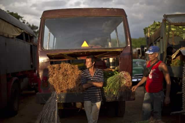 In this September 30, 2013 photo, onion vendors wait for customers at the 114th Street Market on the outskirts of Havana, Cuba. Produce is brought in by growers themselves and by transportation specialists who make a living by buying crops far away and hauling them to Havana, the island's biggest and most important market. (Photo by Ramon Espinosa/AP Photo)