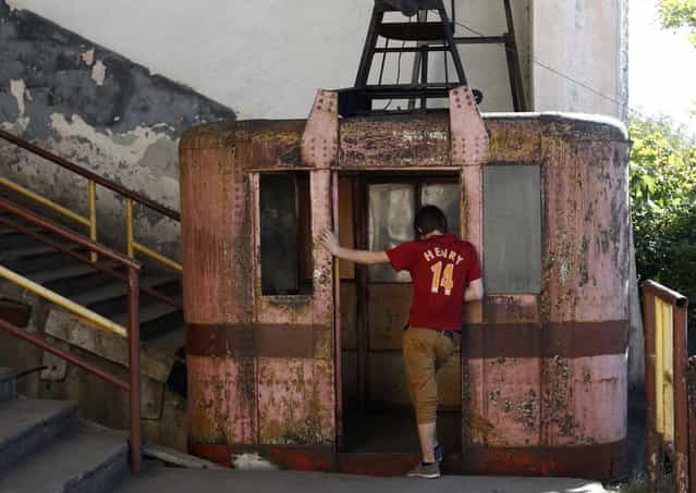 A boy stands at the door of a 60-year-old cable car in the town of Chiatura, some 220 km (136 miles) northwest of Tbilisi, September 12, 2013. (Photo by David Mdzinarishvili/Reuters)