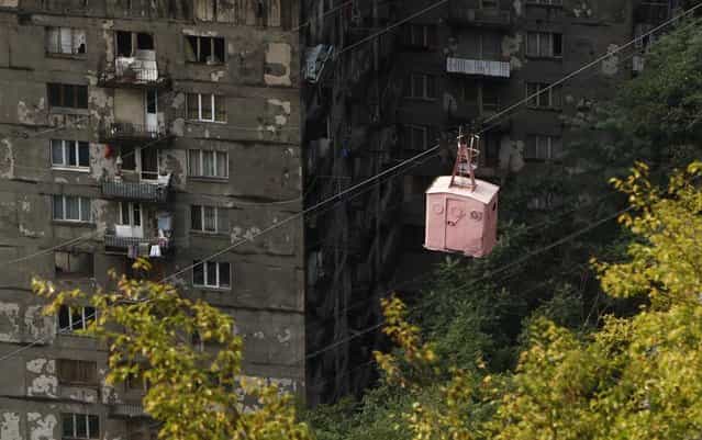 A cable car passes above apartment buildings in the town of Chiatura, some 220 km (136 miles) northwest of Tbilisi, September 25, 2013. (Photo by David Mdzinarishvili/Reuters)