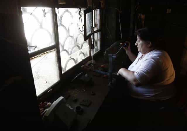 Eliza Kobiashvili, 56, operates 60-year-old cable cars from her booth in the town of Chiatura, some 220 km (136 miles) northwest of Tbilisi, September 12, 2013. (Photo by David Mdzinarishvili/Reuters)