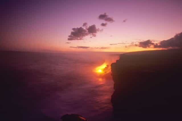 Lava from the Kilauea volcano flows into the sea at sunset, in Kilauea, Hawaii. (Photo by Kirk Aeder/Barcroft Media)