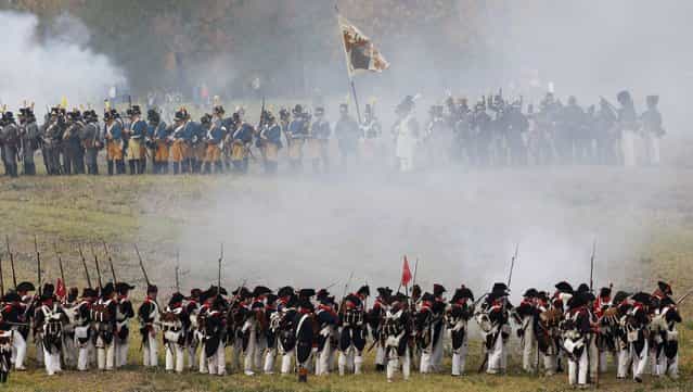 Performers wearing 19th century Allied forces and French military uniforms attack one another during a reenactment of the Battle of the Nations, in a field in the village of Markkleeberg near Leipzig October 20, 2013. The east German city of Leipzig commemorated the 200th anniversary of the largest battle of the Napoleonic Wars on Sunday by reenacting the Battle of the Nations, with 6,000 military-historic association enthusiasts from all over Europe. The decisive encounter in which tens of thousands of soldiers were killed, took place from October 17-19, 1813, just outside of Leipzig. At the height of the hostilities Napoleon fielded more than 200,000 men against an Allied force of some 360,000 soldiers which included troops from Russia, Austria, Prussia and Sweden. (Photo by Fabrizio Bensch/Reuters)