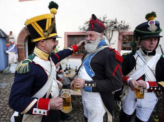 Performers wearing 19th century French military uniform drink beer at a bivouac camp for the reenactment of the Battle of the Nations in the village of Markkleeberg near Leipzig October 19, 2013. The east German city of Leipzig is commemorating the 200th anniversary of the largest battle of the Napoleonic Wars on Sunday by reenacting the Battle of Nations, with 6,000 military-historic association enthusiasts from all over Europe. Some 185,000 French troops and 320,000 allied troops from Austria, Prussia, Russia and Sweden, entered into the decisive battle just outside Leipzig on October 16, 1813. (Photo by Fabrizio Bensch/Reuters)