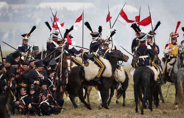 Performers wearing 19th century Allied forces (L, bottom) and French military uniforms attack one another during a reenactment of the Battle of the Nations, in a field in the village of Markkleeberg near Leipzig October 20, 2013. The east German city of Leipzig commemorated the 200th anniversary of the largest battle of the Napoleonic Wars on Sunday by reenacting the Battle of the Nations, with 6,000 military-historic association enthusiasts from all over Europe. The decisive encounter in which tens of thousands of soldiers were killed, took place from October 17-19, 1813, just outside of Leipzig. At the height of the hostilities Napoleon fielded more than 200,000 men against an Allied force of some 360,000 soldiers which included troops from Russia, Austria, Prussia and Sweden. (Photo by Fabrizio Bensch/Reuters)