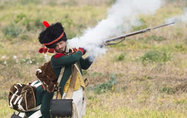 A French soldier fires his weapon during a re-enactement of the Battle of the Nations (Voelkerschlacht) in Leipzig, eastern Germany, on October 20, 2013. This year's re-enactement marks the battle's 200th anniversary, with 6000 enthusiasts taking part. The battle, between the remnants of Napoleon's Grande Armee and a Russo-Prussian coalition, was Napoleon's most crushing defeat. (Photo by John Macdougall/AFP Photo)
