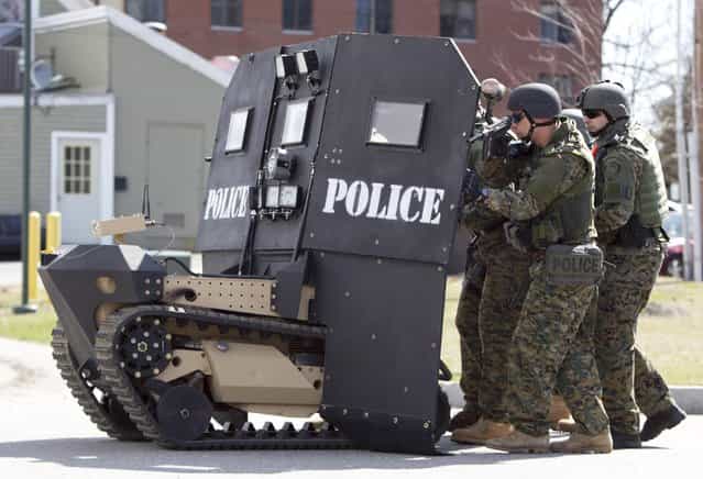 A SWAT robot, a remote-controlled small tank-like vehicle with a shield for officers, is demonstrated for the media in Sanford, Maine, on, April 18, 2013. Howe & Howe Technologies, a Waterboro, Maine company, says their device keeps SWAT teams and other first responders safe in standoffs and while confronting armed suspects. (Photo by Robert F. Bukaty/AP Photo)