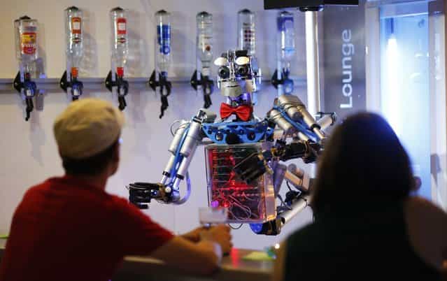 Humanoid robot bartender [Carl] interacts with guests at the Robots Bar and Lounge in the eastern German town of Ilmenau, July 26, 2013. [Carl], developed and built by mechatronics engineer Ben Schaefer who runs a company for humanoid robots, prepares spirits for the mixing of cocktails and is able to interact with customers in small conversations. (Photo by Fabrizio Bensch/Reuters)