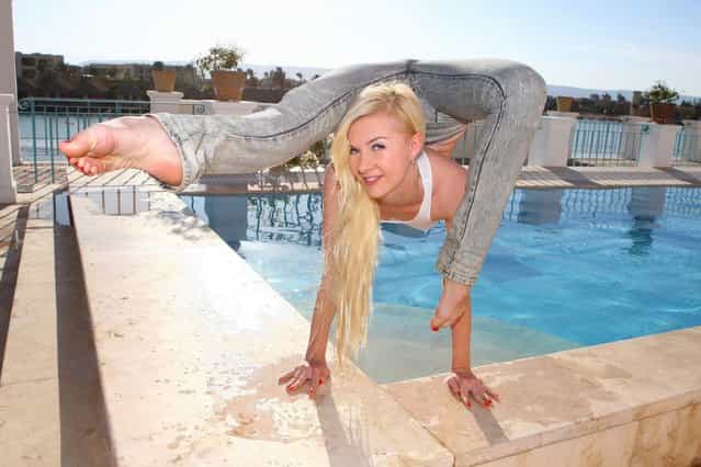 Russian-born Zlata is pictured balanced precariously on the edge of a pool in a gravity-defying pose. (Photo by Barcroft Media)