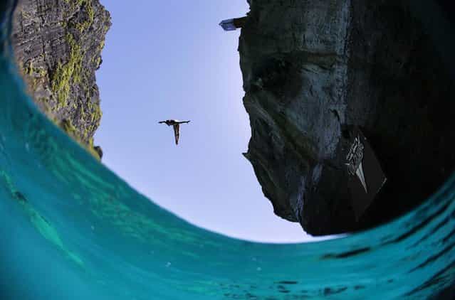 In this handout image provided by Red Bull, Artem Silchenko of Russia dives from the 27 metre platform at Maya Bay in the Andaman Sea during the final stop of the 2013 Red Bull Cliff Diving World Series on October 22, 2013 at Phi Phi Island, Thailand. (Photo by Samo Vidic/Red Bull via Getty Images)