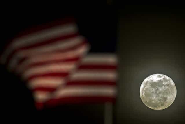 A flag blows in the wind as the moon rises in Brookfield, Wisconsin