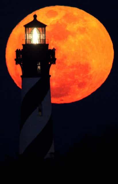 A group of sightseers watch the the moon rise from the top of the St. Augustine Lighthouse during the annual Lighthouse Festival in St. Augustine, Florida
