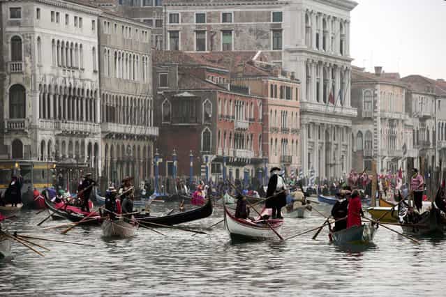 Boats with people wearing costumes sail on the [Canal Grande] during a boat parade during the Carnival February 19, 2006 in Venice, Italy. (Photo by Marco Di Lauro)