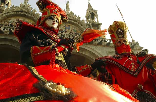 Masked revellers participate in the traditional Venice Carnival in St. Mark's Square February 15, 2004 in Venice, Italy. (Photo by Giuseppe Cacace)