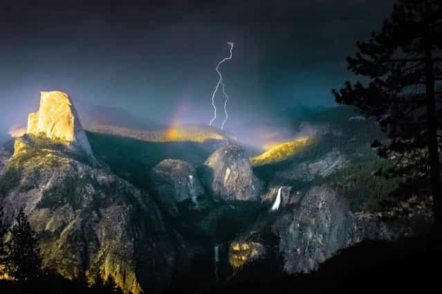 This is the spectacular moment the photographer struck gold – by capturing a bolt of lightning cracking through a rainbow in a freak weather display. (Photo by Nolan Nitschke/Caters News)