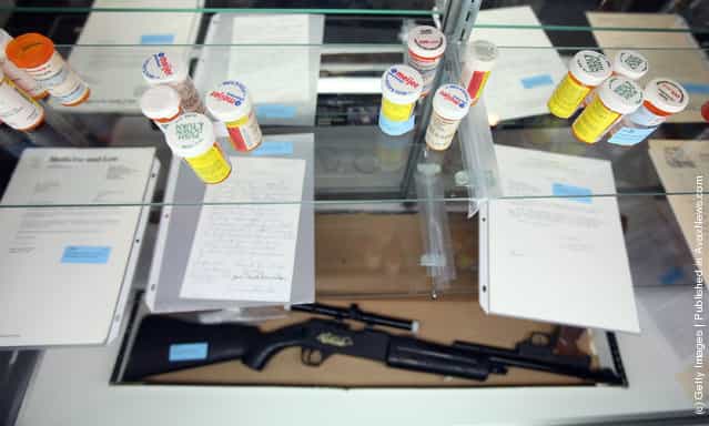 Prescription pill bottles and a BB gun are displayed during a press preview of an auction of the personal effects of Dr. Jack Kevorkian