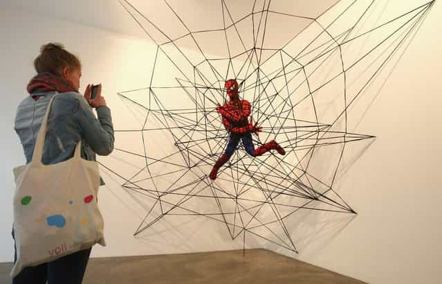 The knitted sculpture Spiderman by Patricia Waller, featuring the comic book character as an imprisoned victim of his own web, hangs in the Broken Heroes exhibition at the Deschler Gallery