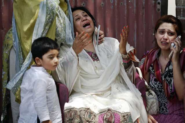 People cry as rescue workers try to save people trapped inside a burning building in central Lahore May 9, 2013. (Photo by Damir Sagolj/Reuters)