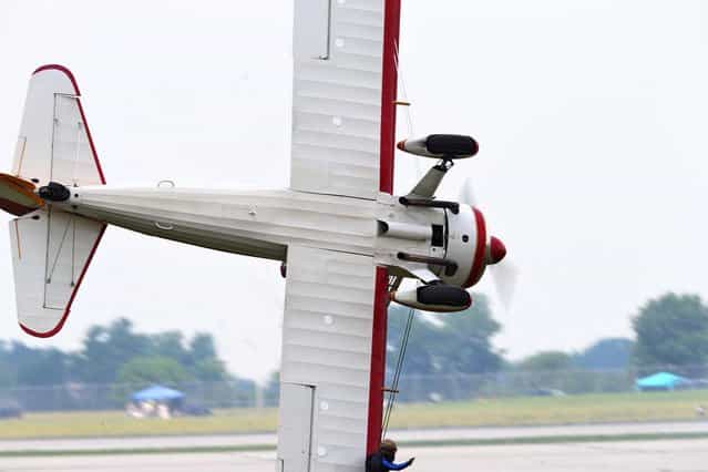 A stunt plane loses control as a wing walker performs at the Vectren Air Show just before crashing, Saturday, June 22, 2013, in Dayton, Ohio. (Photo by Thanh V. Tran/AP Photo)
