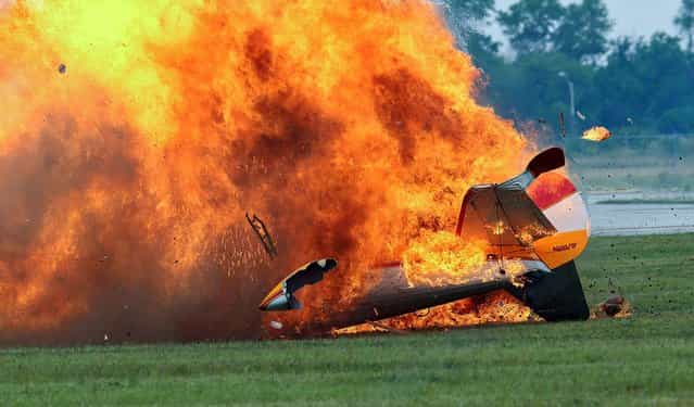 Flames erupt from the stunt plane after the crash. (Photo by Thanh V. Tran/Associated Press)