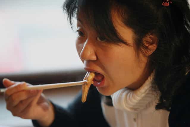 A Chinese woman eats from an ox and dog penis dish at the Guolizhuang [strength in the pot] penis restaurant in China's capital Beijing March 3, 2006. The restaurant offers more than 30 types of animal penises served in a Chinese hotpot style. According to the theory of traditional Chinese medicine, the penis of certain animals is full of nutrients which brings men energy. And because it contains gelatine albumen, it is said to have excellent cosmetic effects for women, especially beneficial for the skin. (Photo by Reinhard Krause/Reuters)
