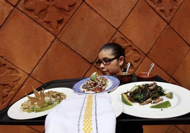 A waitress carries plates of ant eggs (L), maguey worms (R) and grasshoppers at the Corazon de Maguey restaurant in Mexico City June 18, 2013. (Photo by Henry Romero/Reuters)