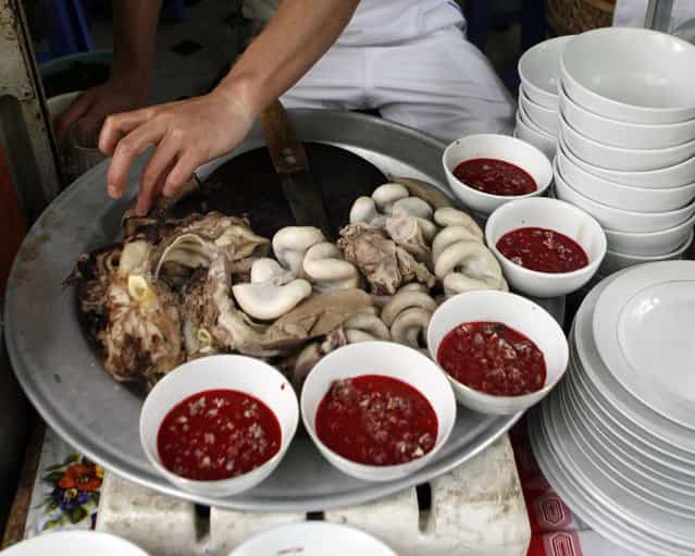 A raw blood dish is displayed with cooked entrails at a restaurant in Hanoi April 28, 2009. Frozen pudding from fresh duck or pig blood is a popular dish in the Southeast Asian country although duck blood is less consumed following bird flu outbreaks that have killed at least 55 Vietnamese since late 2003. In Vietnam, there appeared to be a degree of confusion towards swine flu which is not in fact linked to pigs alone – but an assortment of swine, human and avian viruses. One bowl of raw blood costs VND10,000 ($0.55). (Photo by Reuters/Kham)