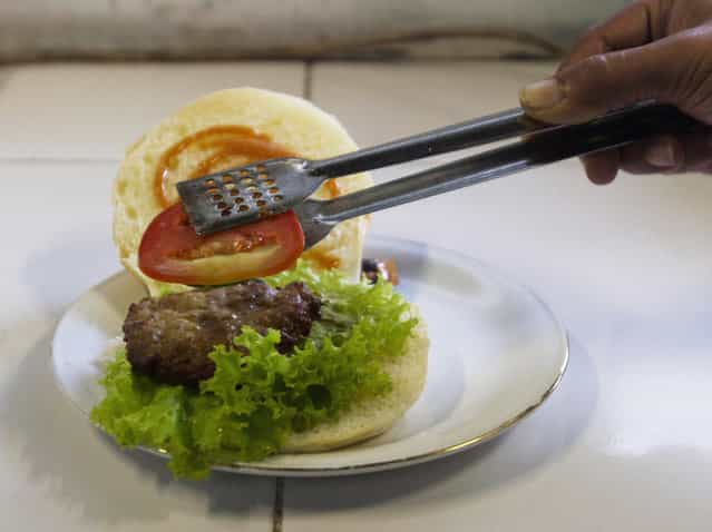 A chef prepares a cobra meat burger at a Chinese restaurant in the ancient city of Yogyakarta April 1, 2011. Snake hunters catch about 1,000 cobras from Yogyakarta, Central Java and East Java provinces each week to harvest their meat for burgers, priced at 10,000 rupiah ($1.15) each, as well as satay and other dishes. Some customers said they believe cobra meat can cure skin diseases and asthma, and increase sexual virility. (Photo by Dwi Oblo/Reuters)