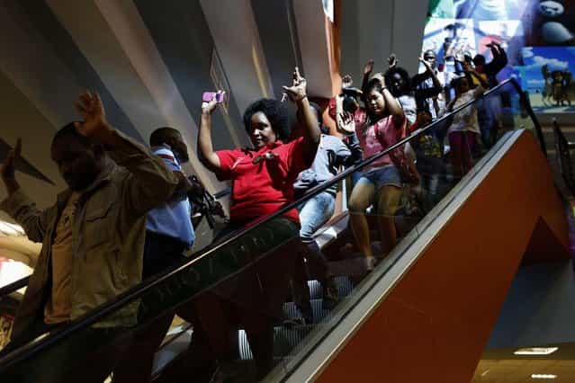 Civilians escape an area at the Westgate Shopping Centre. (Photo by Siegfried Modola/Reuters)