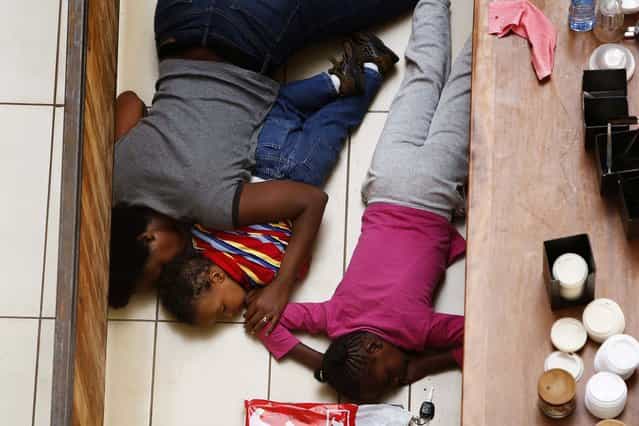 A mother and her children hide from gunmen inside the mall. (Photo by Siegfried Modola/Reuters)