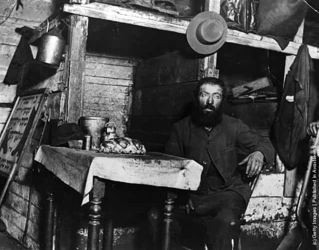 A Jewish cobbler ready for Sabbath Eve in a coal cellar in New York, where he is living with his family, 1887