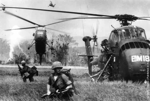 US marine troops find themselves waist-high in swampy fields, as they jump from Sikorsky S-55 helicopters