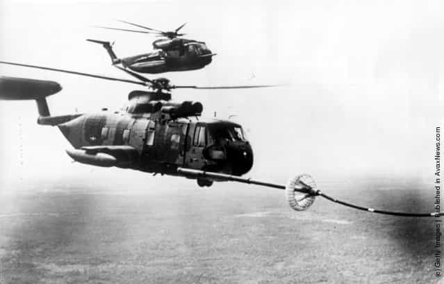 Two battle modified US Sikorsky S-61 helicopters being refuelled in mid-air over Vietnam