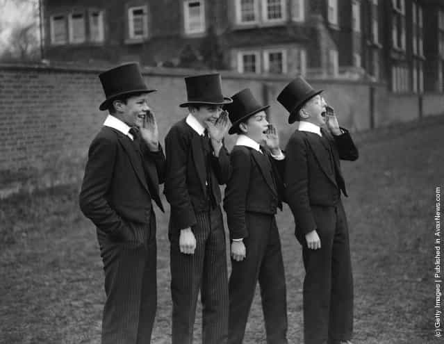 1928: A group of public school boys watch their classmates playing the Eton Wall Game, traditionally played between town and school on St Andrews Day, and unique to Eton.