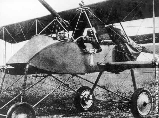 A Russian officer fastens a bomb to the side of his warplane before take off, 1915