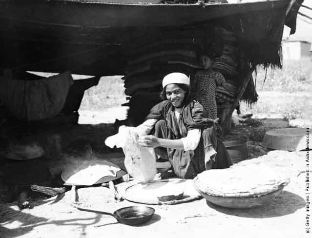 A Bedouin woman cooking flatbread outside her tent in Israel, circa 1950