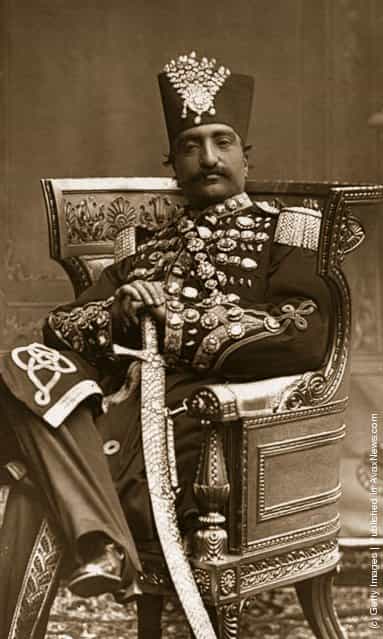 1880: Nasiruddin, Shah of Persia (Iran) in regal attire, with his scimitar