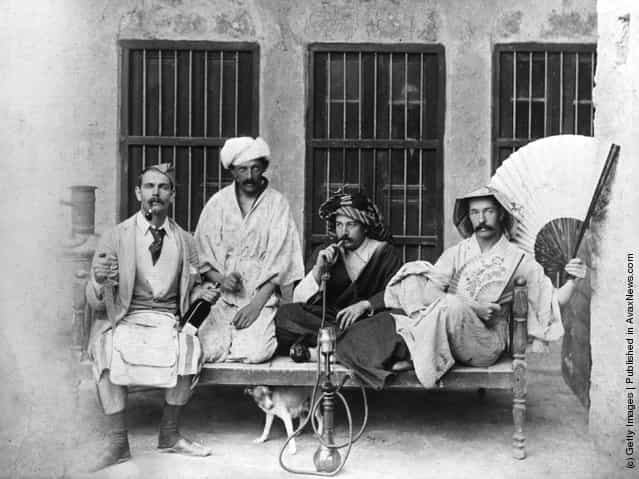 1910: From left to right: Messrs. Gunning, Thornton, Wood and Garden relaxing in Bustine, Persia. Mr Wood is smoking a hookah pipe