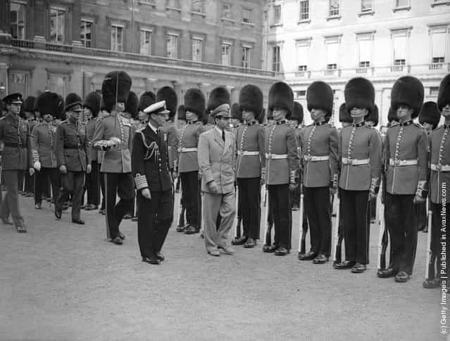 1948: The Shah of Persia, accompanied by King George VI, inspecting the guard of honour of the 2nd Battalion Coldstream Guards at Buckingham Palace