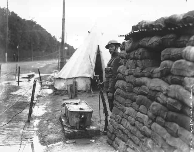 1920: A British soldier on sentry duty outside a sandbagged blockhouse on Orange Day at Belfast