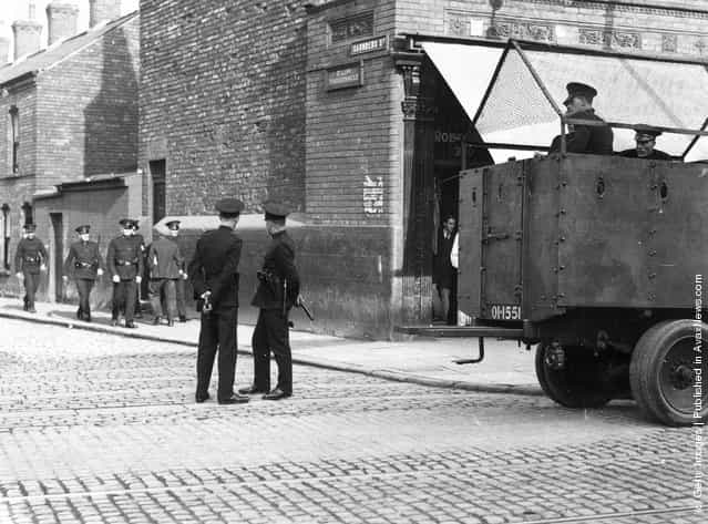1932: Belfast police patrol the streets with an armoured car following rioting between the unemployed and police leaving one man dead and 46 injured