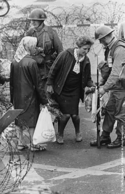 1969: British troops search a womans shopping at a check point in the Falls Road area of Belfast