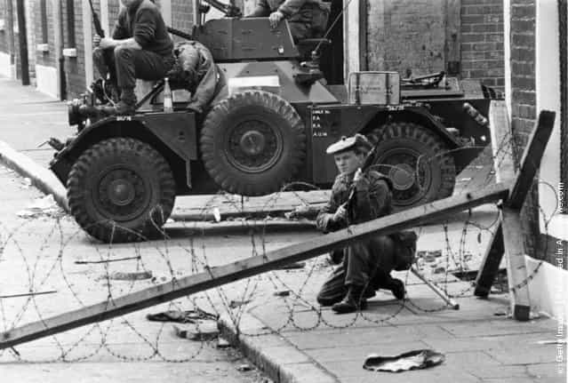 1970: British troops and a Ferret armoured car guard a sectarian divide on the streets of Belfast