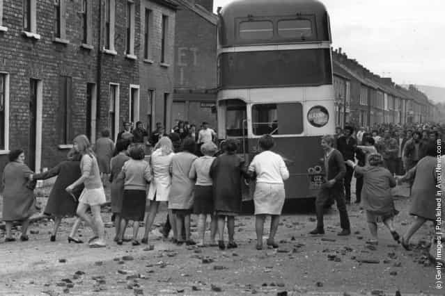 1970: A commandeered bus is driven backwards through a picket of women who want the violence to end during riots on the Falls Road, Belfast