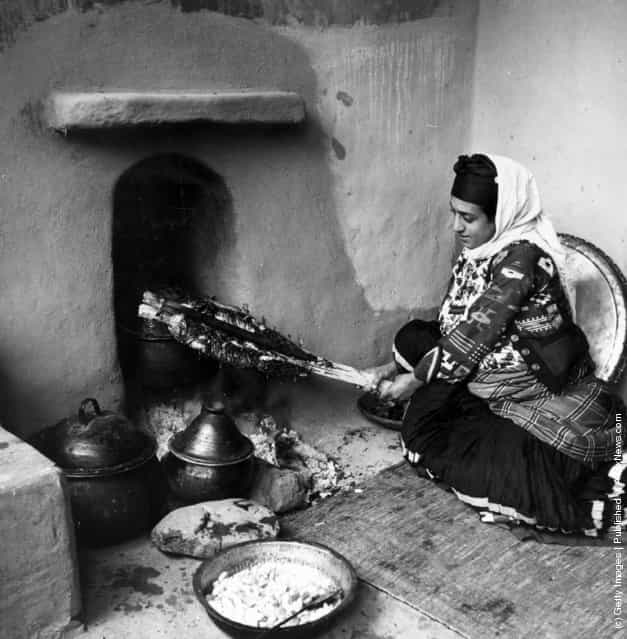 1950: A peasant woman roasts a joint of meat in the Muslim manner, in the Mazanderan province of northern Iran